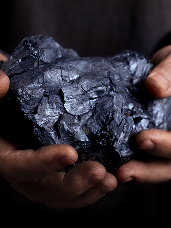 photo line - hands holding a large chunk of coal hands holding a large chunk of coal